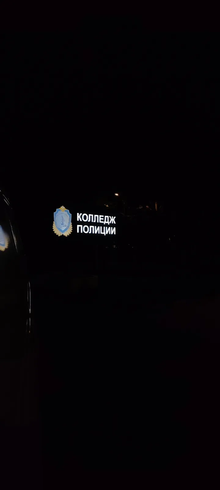 Светящаяся вывеска «Колледж полиции» ночью